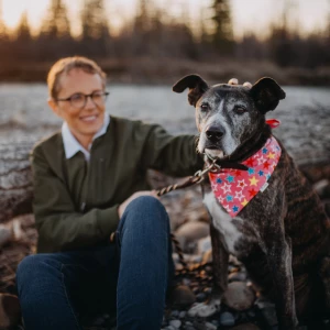 Cat the owner of ImPAWSible Possible dog training calgary sitting on a rock with her dog Mouse, enjoying the serene surroundings and the company of her loyal companion.